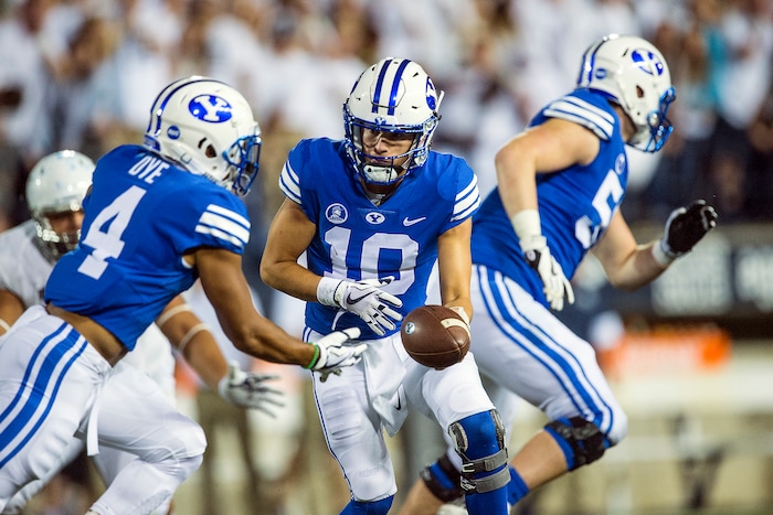 (Chris Detrick  |  The Salt Lake Tribune)  Brigham Young Cougars quarterback Koy Detmer Jr. (10) hands off to Brigham Young Cougars running back Trey Dye (4) during the game at Merlin Olsen Field at Maverik Stadium Friday, September 29, 2017.