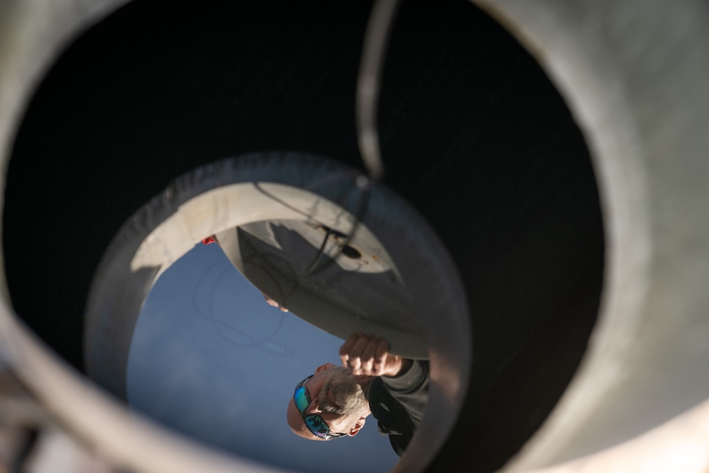 (Erin Schaff | The New York Times) Russell Cox, a resident, is reflected in the water in his underground water storage tank in Rio Verde, Ariz., on Sunday, Jan. 8, 2023. Hundreds of homes outside the boundaries of Scottsdale can no longer get water from the city, now their owners are living in a worst-case scenario of drought in the West.