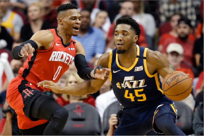 Utah Jazz guard Donovan Mitchell (45) dribbles as Houston Rockets guard Russell Westbrook defends during the first half of an NBA basketball game, Sunday, Feb. 9, 2020, in Houston. (AP Photo/Eric Christian Smith)