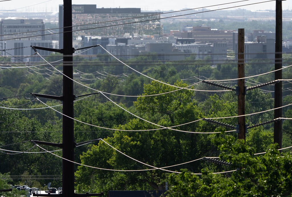 (Francisco Kjolseth | The Salt Lake Tribune) Power lines are reflected in the setting sun along 800 South in Salt Lake City on Wednesday, July 20, 2022. Inflation and changes in energy are putting pressure on home electricity prices in Utah.