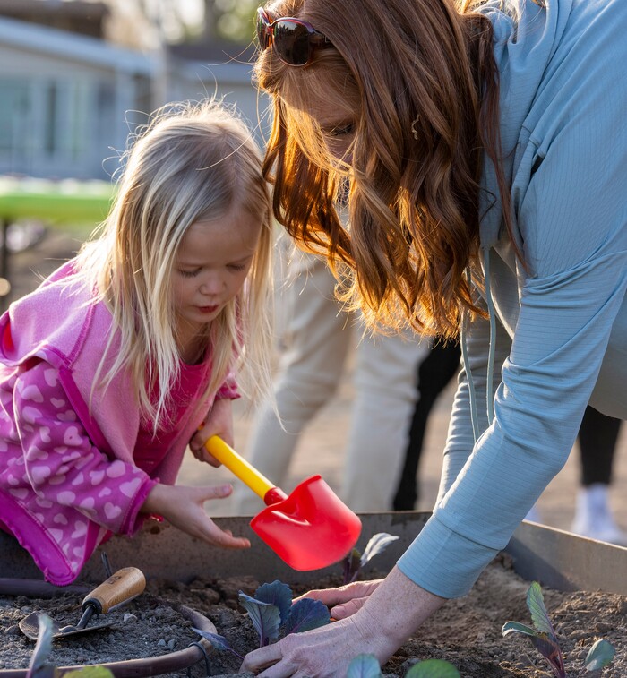 (Rick Egan | The Salt Lake Tribune)  Jennie Taylor helps her daughter Eleanor plant a cabbage, during the Earth Day Party at the Mini Taylor farm at at the Jennie Taylor's residence, in North Ogden. Taylor is the widow to the late Major. Brent Taylor, killed in 2018 while on Army National Guard duty in Afghanistan, donations have helped restore the small family farm, with planter boxes, a chicken coop, and a sandbox for the kids, on Thursday, April 22, 2021.