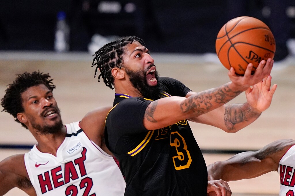 (Mark J. Terrill | AP) Los Angeles Lakers forward Anthony Davis shoots past Miami Heat forward Jimmy Butler during the second half in Game 5 of basketball's NBA Finals in Lake Buena Vista, Fla., Oct. 9, 2020.
