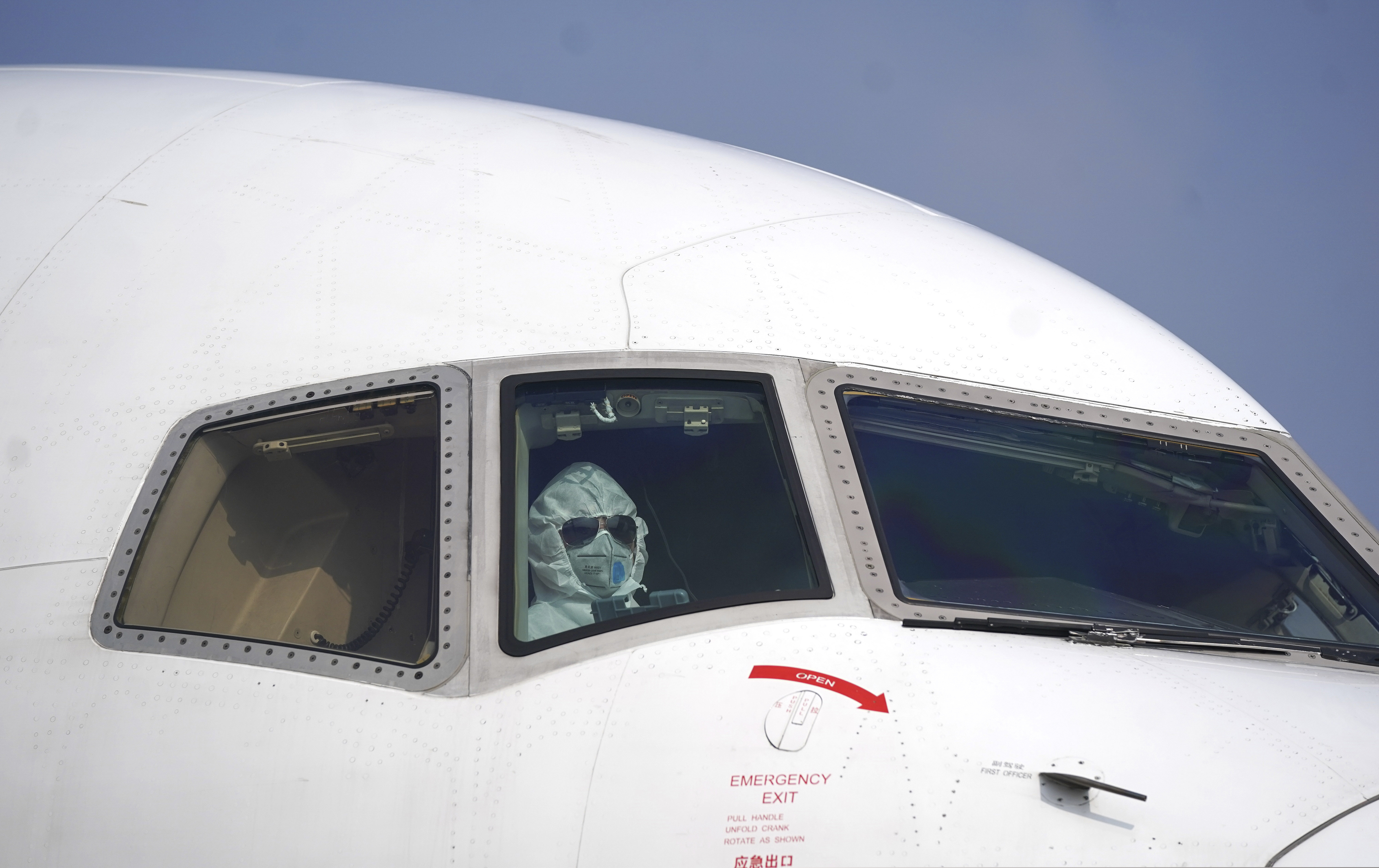 (Cheng Min | Xinhua via AP) In this photo released by China's Xinhua News Agency, a pilot wearing a protective suit parks a cargo plane at Wuhan Tianhe International Airport in Wuhan in central China's Hubei Province, Tuesday, Jan. 28, 2020. Hong Kong's leader announced Tuesday that all rail links to mainland China will be cut starting Friday as fears grow about the spread of a new virus.