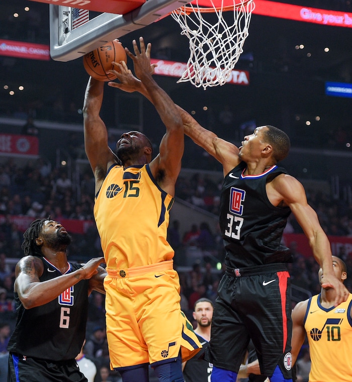 Los Angeles Clippers forward Wesley Johnson, right, blocks a shot by Utah Jazz forward Derrick Favors, center, as center DeAndre Jordan watches during the first half of an NBA basketball game in Los Angeles, Thursday, Nov. 30, 2017. (AP Photo/Kelvin Kuo)