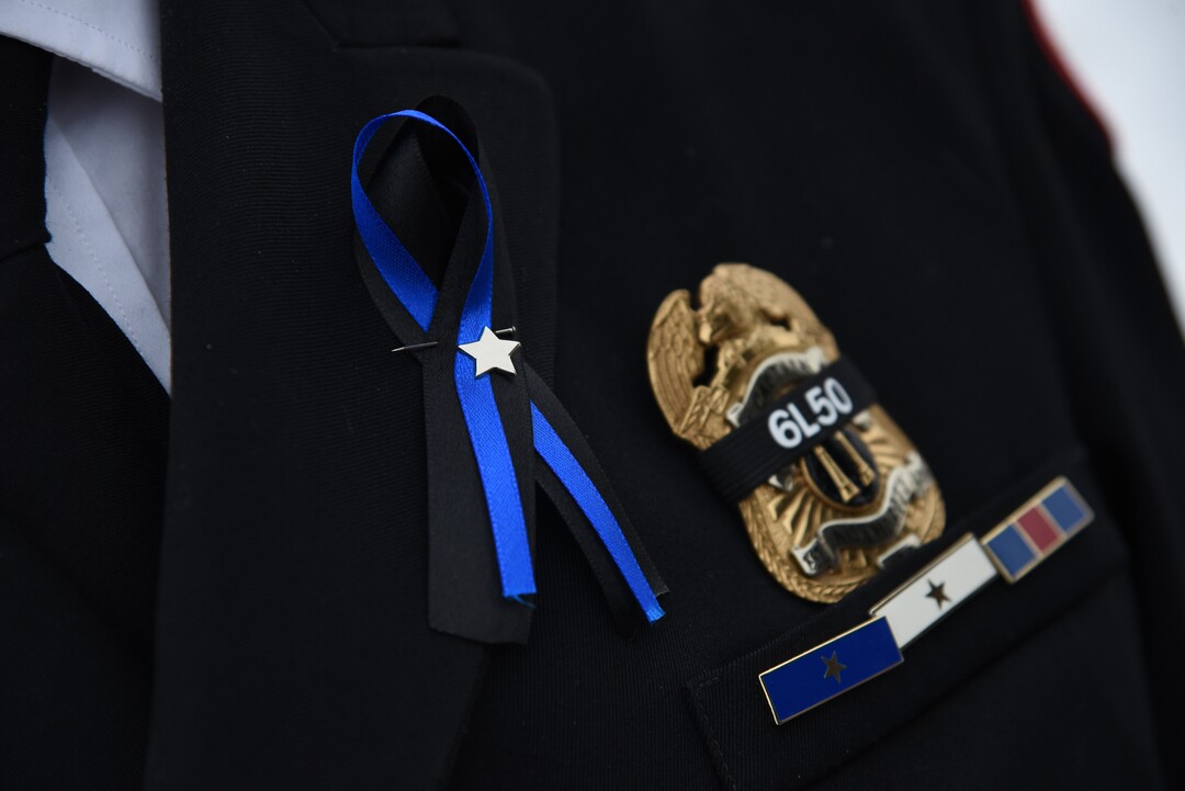 (Francisco Kjolseth  |  The Salt Lake Tribune)  Numerous public service agency members pin ribbons to their uniforms in honor of police officer David Romrell during funeral services at Larkin Sunset Gardens Cemetery in Sandy, Wed. Dec. 5, 2018.