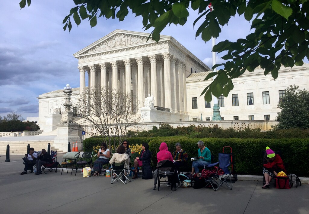 In this April 23, 2018, photo, people wait in line outside the Supreme Court in Washington, to be in the gallery when the court hears arguments in on April 25, over President Donald Trump’s ban on travelers from several mostly Muslim countries. (AP Photo/Jessica Gresko)