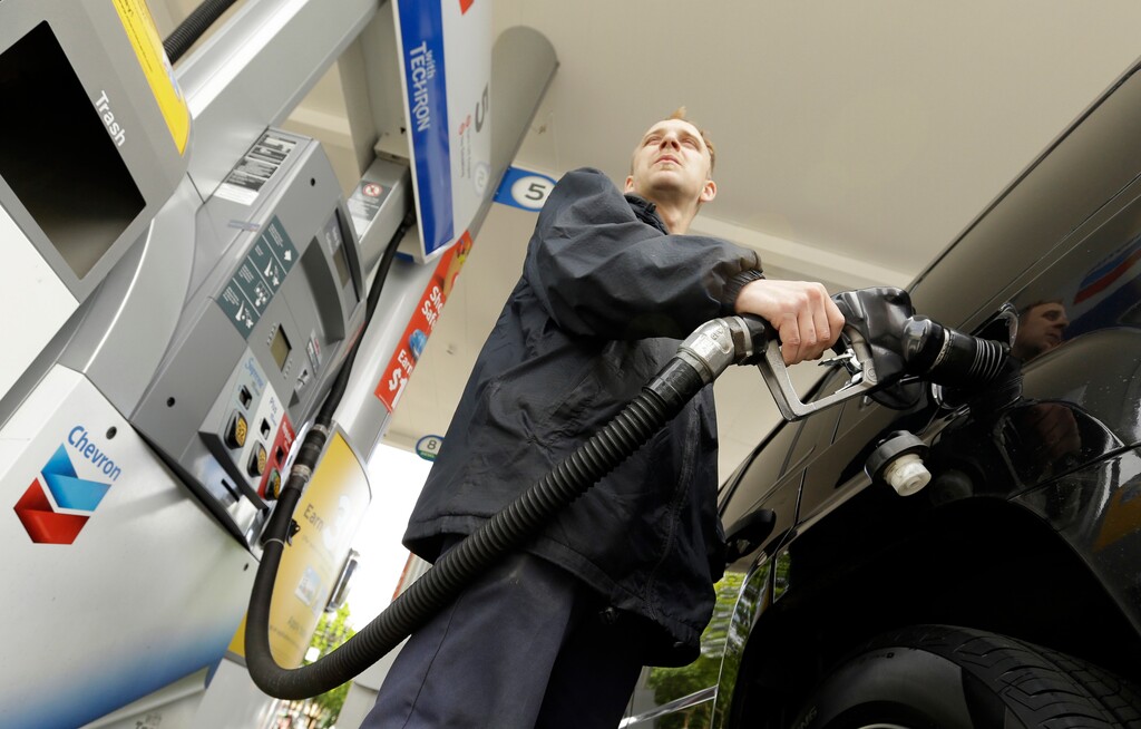 FILE- In this May 6, 2015 file photo, attendant James Lewis pumps gas at a station in Portland, Ore. An Oregon law passed nearly seven decades ago banned drivers from pumping their own gas but now that's changing, in some cases. The new year ushered in some modifications to the aging law that makes Oregon only one of two states in the U.S. that places restrictions on self-service gas. (AP Photo/Don Ryan, File)