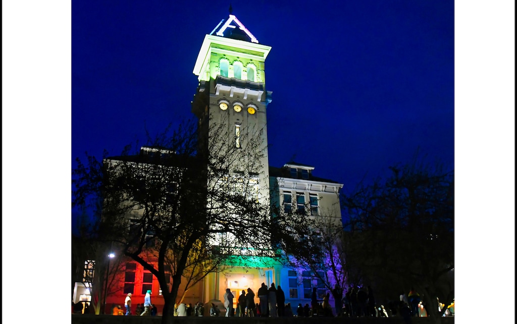 (Eli Lucero |Herald Journal) Old Main on the campus of Utah State University is lit up in rainbow colors on Tuesday, April 13, 2021, in Logan. 
