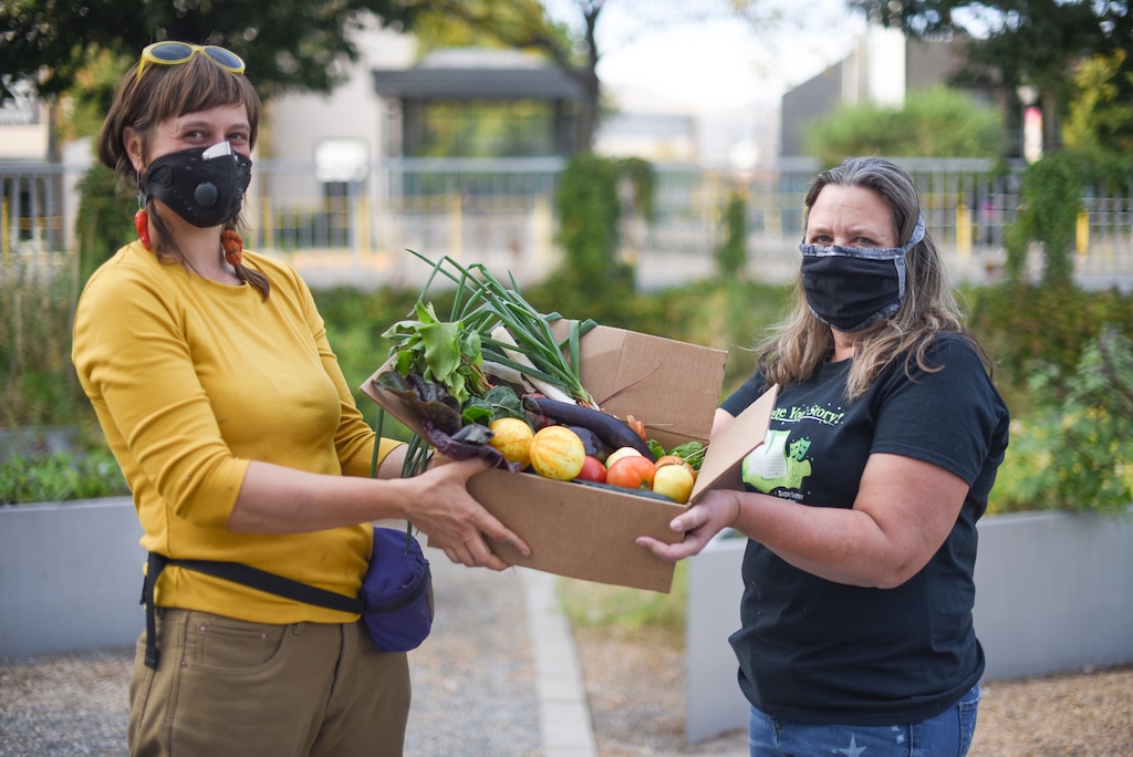 (Photo by Jeri Gravlin, courtesy of the City Library) Library employees Rikki Longino and Donnae Tidwell hold a box of vegetables grown in the library's community garden. The downtown Salt Lake City Public Library has four open community garden plots that will be assigned through a raffle that closes on Feb. 1.