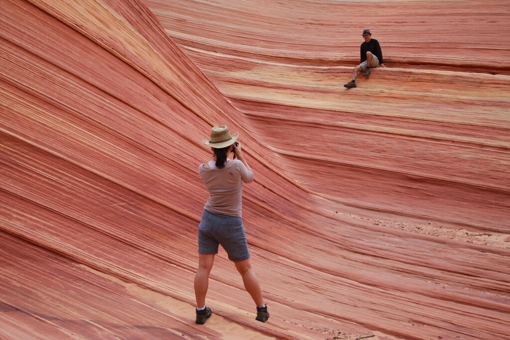 (Brian Witte | AP file photo) In this May 28, 2013, photo, a hiker takes a photo on a rock formation known as The Wave in the Vermilion Cliffs National Monument in Arizona.