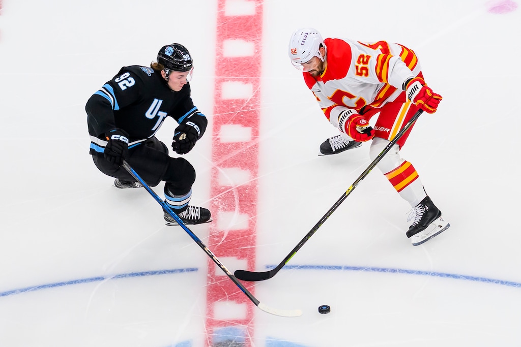 (Tyler Tate | AP) Utah center Logan Cooley (92) and Calgary Flames defenseman MacKenzie Weegar (52) battle for possession of the loose puck during the first period of an NHL hockey game Tuesday, April 1, 2025, in Salt Lake City. Weegar joined the Utah Mammoth at the trade deadline in March 2026.