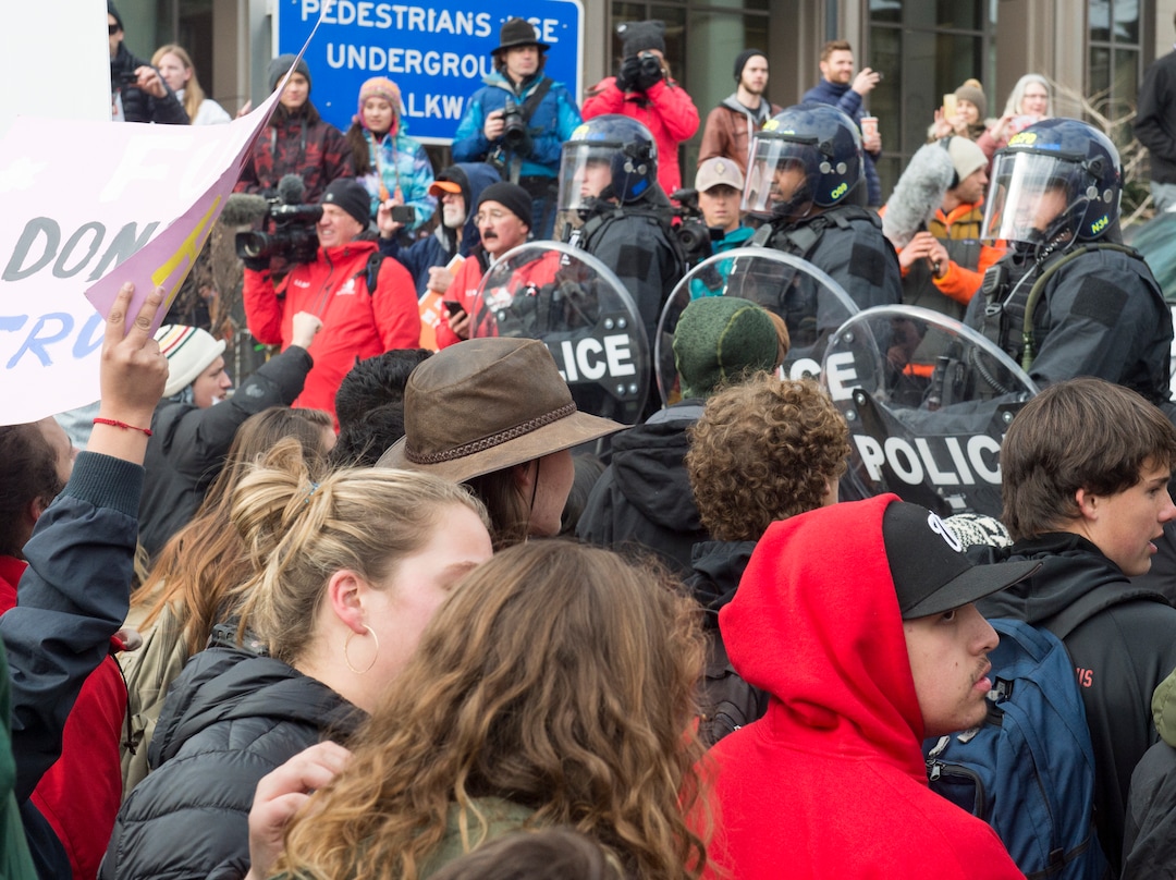 (Rick Egan  |  The Salt Lake Tribune)  Protesters kneel down as they face the Riot Police, while blocking traffic on State Street, during President Trump's visit to Salt Lake CIty, Monday, December 4, 2017.