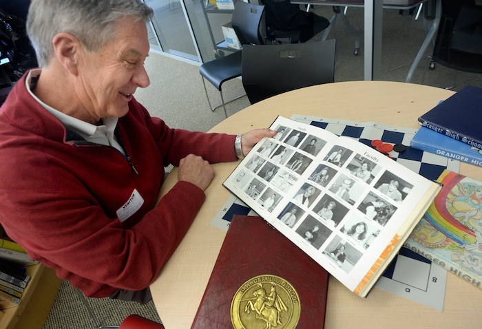 (Scott Sommerdorf   |  Tribune File Photo)  University of Utah athletic director Chris Hill looks through a yearbook from his time at Granger High School, Thursday, February 9, 2017. Early in his career, Hill spent four years at Granger High as a math teacher and basketball coach. 