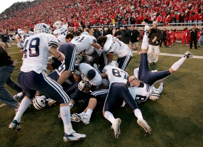 Brigham Young players pile on tight end Jonny Harline (13) after his winning touchdown catch after as time ran out to beat Utah 33-31 in 2006. (AP Photo/Douglas C. Pizac)