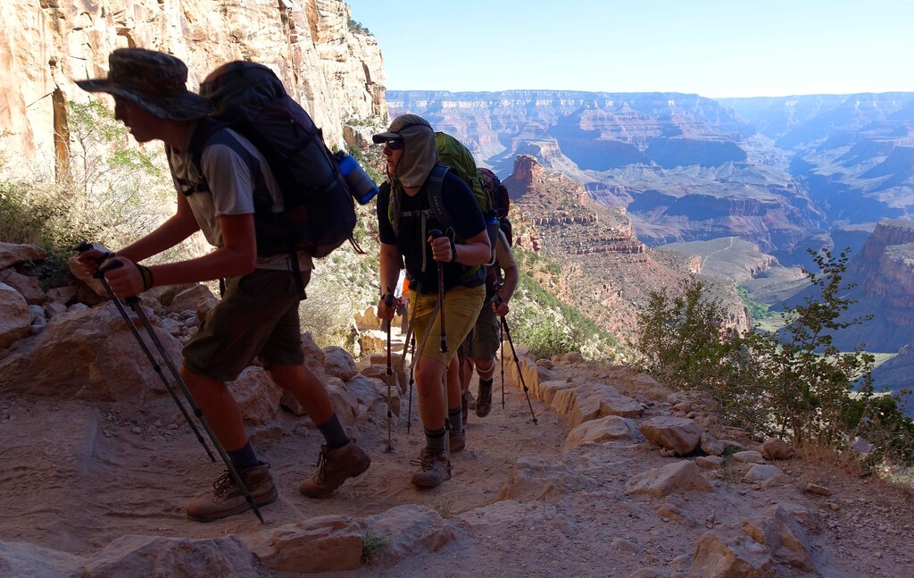 FILE - In this July 27, 2015, file photo, a long line of hikers head out of the Grand Canyon along the Bright Angel Trail at Grand Canyon National Park, Ariz. The National Park Service is floating a proposal to increase entrance fees at 17 of its most popular sites next year. (AP Photo/Ross D. Franklin, File)