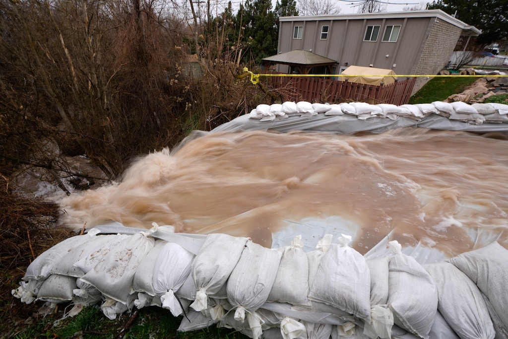 (Francisco Kjolseth | The Salt Lake Tribune) Crews continue to mitigate high water from Emigration Creek in Salt Lake City as they redirect water across 1700 South and back into the creek through Wasatch Hollow Park on Thursday, April 13, 2023.