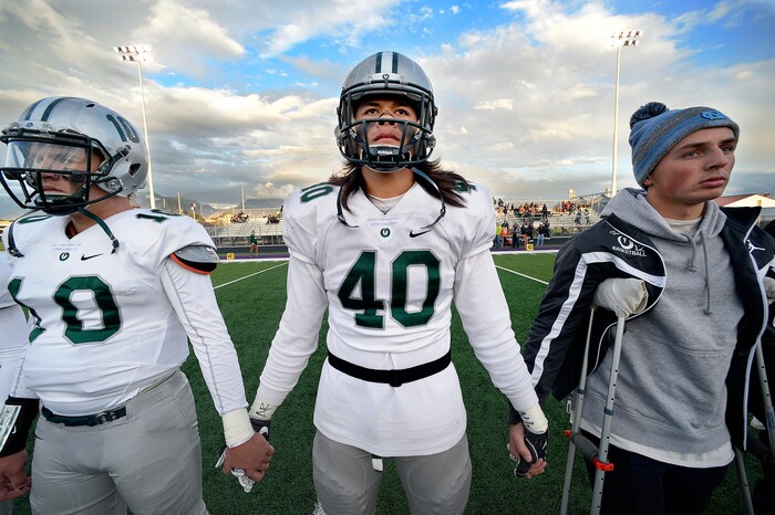 (Scott Sommerdorf   |  The Salt Lake Tribune)   Olympus DE Cameron Latu, #40, holds hands with team mates as they watch the coin toss prior to their matchup with Lehi in Lehi, Friday, September 22, 2017.