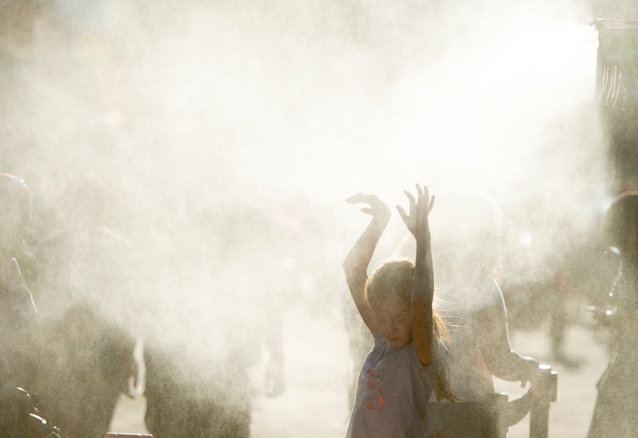 (Rick Egan  |  The Salt Lake Tribune)   A fair goer cools off in the mist of the Slush shack, at the Utah State Fair, Sunday, September 10, 2017.


