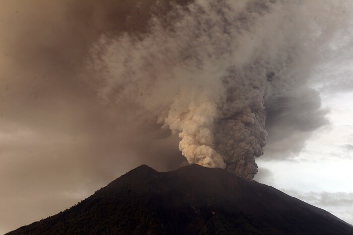(Firdia Lisnawati | The Associated Press) Clouds of ashes rise from the Mount Agung volcano erupting in Karangasem, Indonesia, Monday, Nov. 27, 2017. Indonesia authorities raised the alert for the rumbling volcano to highest level on Monday and closed the international airport on tourist island of Bali stranding thousands of travelers.