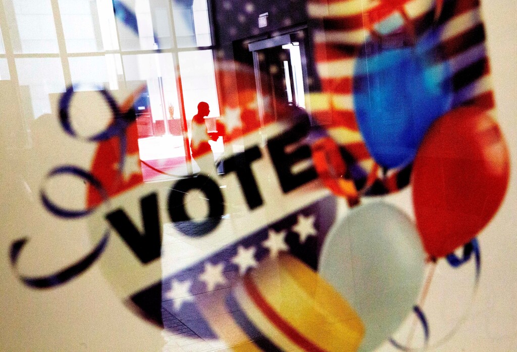 (David Goldman | The Associated Press) In this Nov. 1, 2016, photo, a voter is reflected in the glass frame of a poster while leaving a polling site during early voting ahead of next week's election in Atlanta. Hillary Clinton may not be accumulating the type of early-vote advantage her campaign wanted, but she continues to maintain an apparent edge over Donald Trump, with roughly one-fourth of all expected ballots cast in the 2016 election.