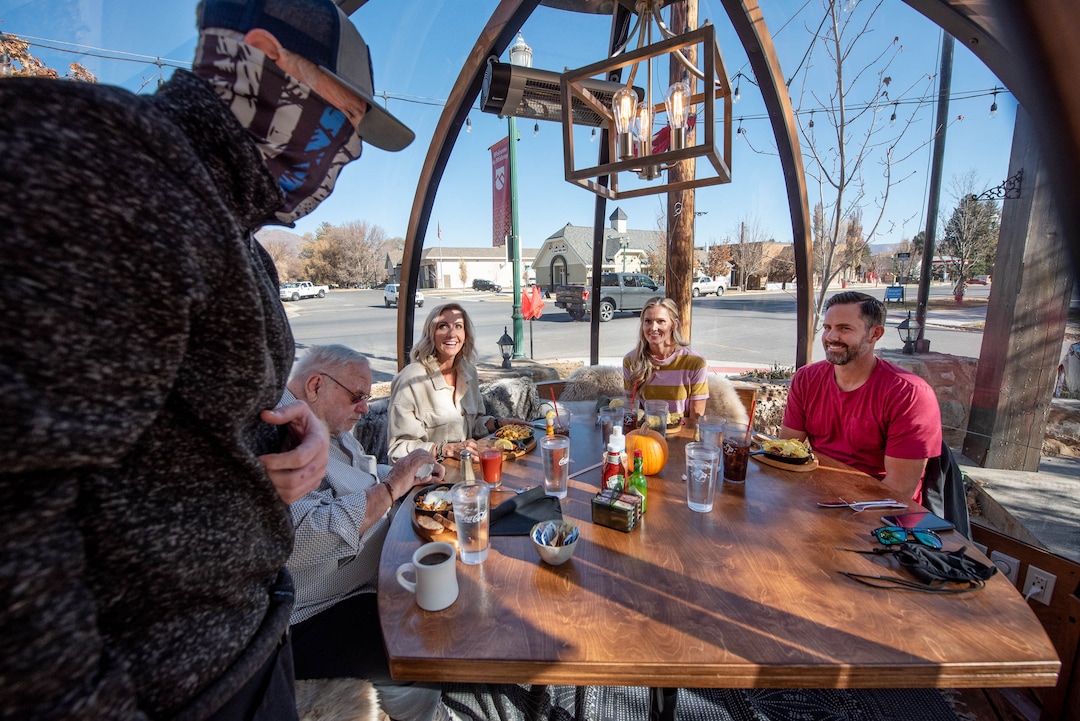 (Francisco Kjolseth  |  The Salt Lake Tribune) Server Michael Johnson, left, checks in with customers Dale Hubbard, Dawn Seare and Dusty and Tim Colyar, from left, as they enjoy breakfast inside the dome-like Alpenglobes that allow diners to eat inside a warm environment, while also being separated from others at Cafe Galleria in Midway on Thursday, Nov. 5, 2020. The owners were trying to find a way to use their outdoor patio in the winter, teaming up with Insight Exhibit, a Salt Lake City corporate event company that was looking for a way to make money while large gatherings have been cancelled.