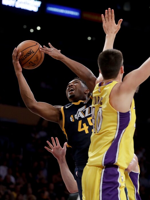 Utah Jazz guard Donovan Mitchell, left, shoots around Los Angeles Lakers center Ivica Zubac during the first half of an NBA basketball game in Los Angeles, Tuesday, Oct. 10, 2017. (AP Photo/Chris Carlson)