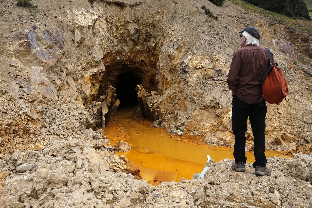 Pete McKay, San Juan County commissioner in Colorado, looks at the site, Monday, Aug. 10, 2015, where the Gold King Mine breach occurred, north of Silverton, Colo. Local officials in towns downstream from where millions of gallons of mine waste spilled into the San Juan River are demanding answers about possible long-term threats to the water supply. The 3 million gallons of mine waste included high concentrations of arsenic, lead and other heavy metals. Workers with the EPA accidentally unleashed the spill Wednesday as they inspected the abandoned mine site. (Jon Austria/The Daily Times via AP)