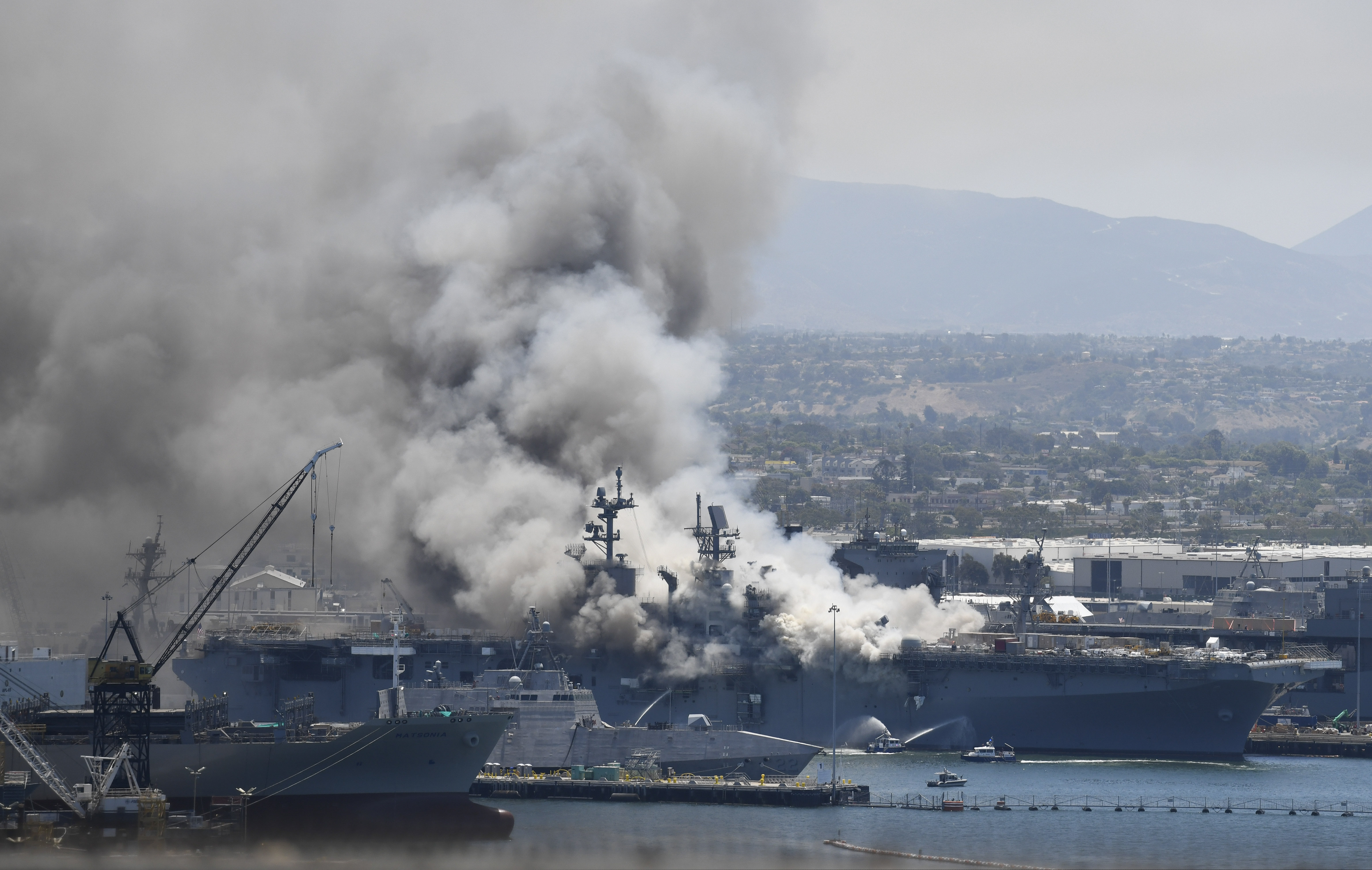 (Denis Poroy | AP file photo)  Smoke rises from the USS Bonhomme Richard at Naval Base San Diego Sunday, July 12, 2020, in San Diego after an explosion and fire Sunday on board the ship at Naval Base San Diego.