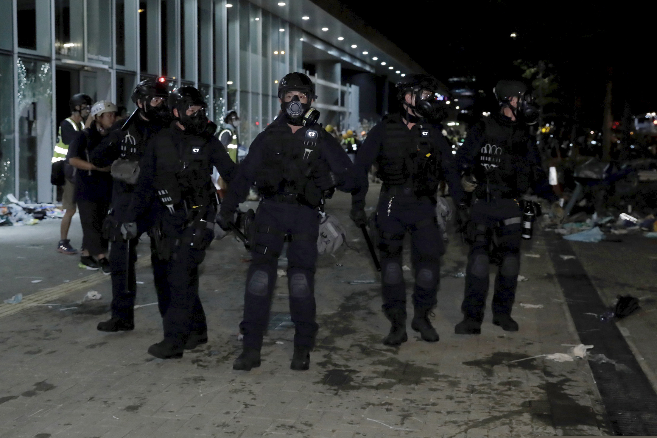 (Kin Cheung | AP Photo) Police officers with protective gear prepare to clear protesters from the Legislative Council in Hong Kong, during the early hours of Tuesday, July 2, 2019.  Protesters in Hong Kong took over the legislature's main building Friday night, tearing down portraits of legislative leaders and spray painting pro-democracy slogans on the walls of the main chamber.