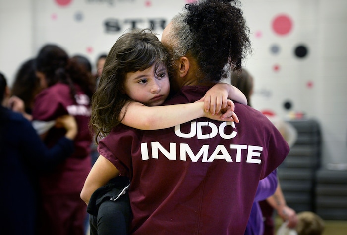 (Scott Sommerdorf   |  The Salt Lake Tribune)   Inmate Angela Rekoutis holds her daughter Ava during "Kids Day" at the Utah State Prison, Saturday, October 7, 2017. 