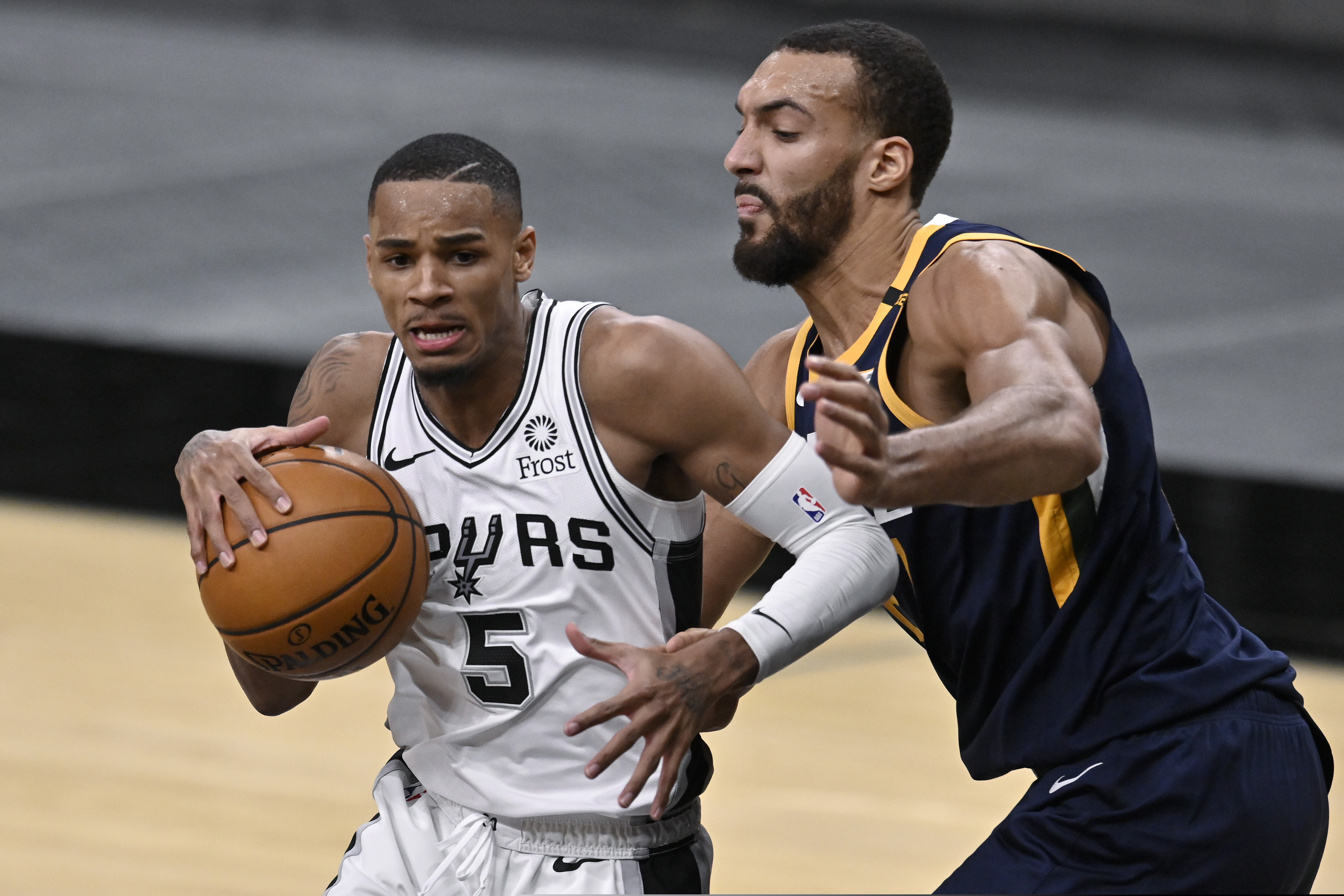 San Antonio Spurs' Dejounte Murray (5) drives around Utah Jazz's Rudy Gobert during the second half of an NBA basketball game, Sunday, Jan. 3, 2021, in San Antonio. (AP Photo/Darren Abate)