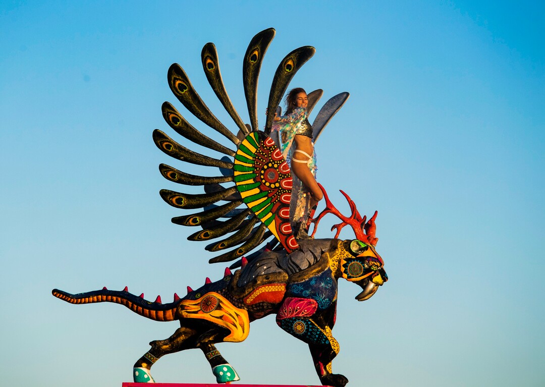 (Rick Egan  |  The Salt Lake Tribune)  Svetlani Shirokikh from the south Russia, stands on top of a scientific reproductions of a neanderthal and a saber-toothed tiger, titled "Transmutation" by Arturo Gonzalez, at Burning Man, Saturday, Aug. 31, 2019.