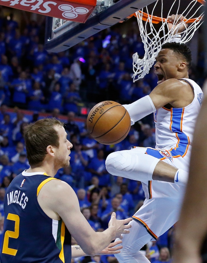 Oklahoma City Thunder guard Russell Westbrook, right, dunks in front of Utah Jazz forward Joe Ingles (2) in the first half of Game 1 of an NBA basketball first-round playoff series in Oklahoma City, Sunday, April 15, 2018. (AP Photo/Sue Ogrocki)