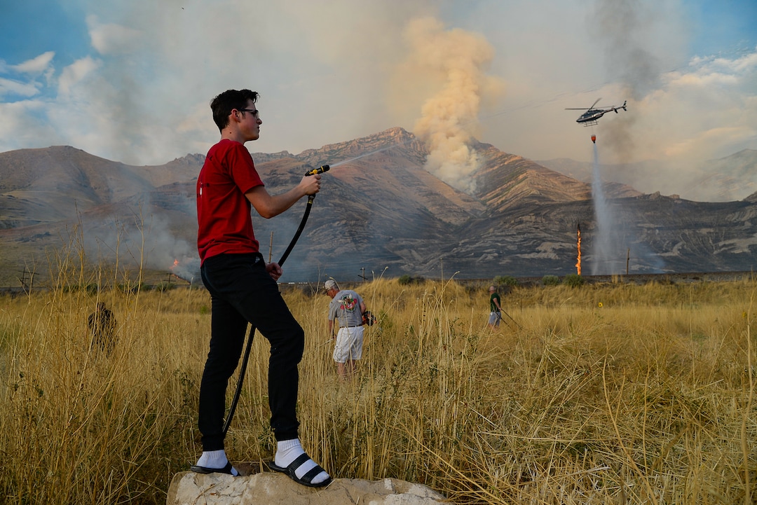 (Francisco Kjolseth  |  The Salt Lake Tribune)  Caden Terry, 15, does what he can as he joins neighbors in cutting down tall brush as crews battle a grass fire in Tooele county being dubbed the Green Ravine fire as it burns on Tuesday, Sept. 3, 2019.