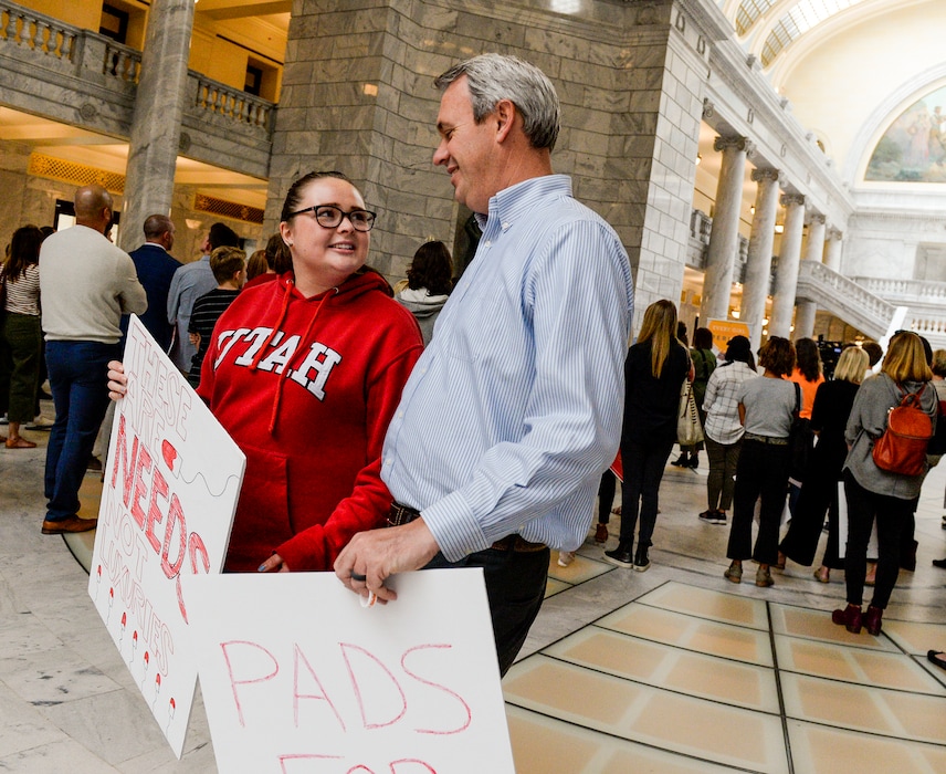 (Leah Hogsten | The Salt Lake Tribune) Sara Shumway, 16, left, and her father Roger Shumway, attend a rally Wednesday focused on making menstrual products more accessible and eliminating the sales tax on the items.