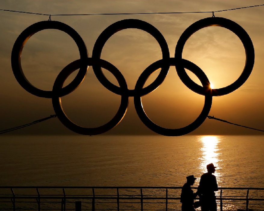 (Charlie Riedel | AP) People stand under a set of Olympic Rings as they watch the sun set over the Black Sea a day after the close of the 2014 Winter Olympics, in Sochi, Russia, Monday, Feb. 24, 2014.