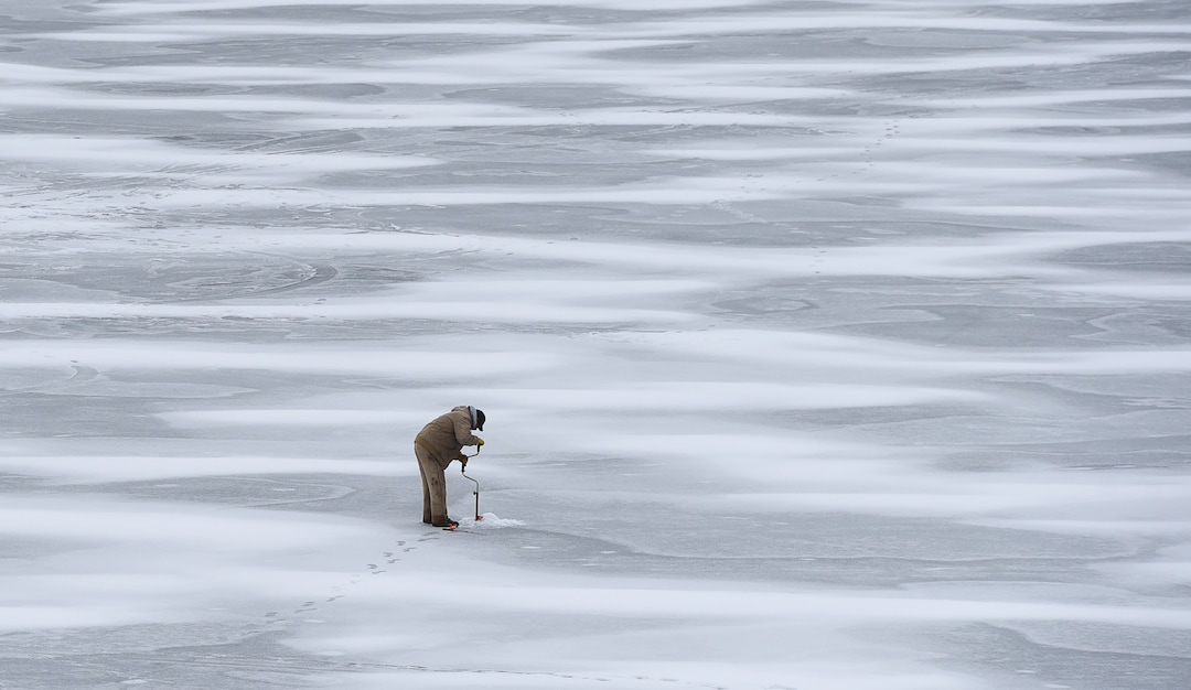 (Francisco Kjolseth  |  The Salt Lake Tribune)  An ice fisherman uses a hand powered auger to drill through the ice at Echo Reservoir in Summit County next to Coalville which could soon become a state park.