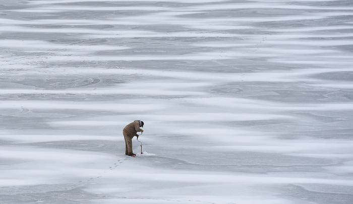(Francisco Kjolseth | The Salt Lake Tribune) An ice fisherman uses a hand powered auger to drill through the ice at Echo Reservoir in Summit County next to Coalville which could soon become a state park.