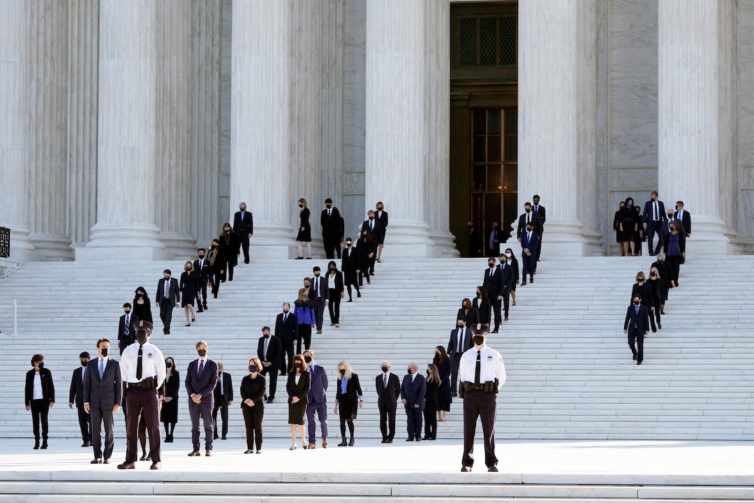 Former law clerks walk out and stand for the casket of Justice Ruth Bader Ginsburg to arrive at the Supreme Court in Washington, Wednesday, Sept. 23, 2020. Ginsburg, 87, died of cancer on Sept. 18. (AP Photo/Patrick Semansky)
