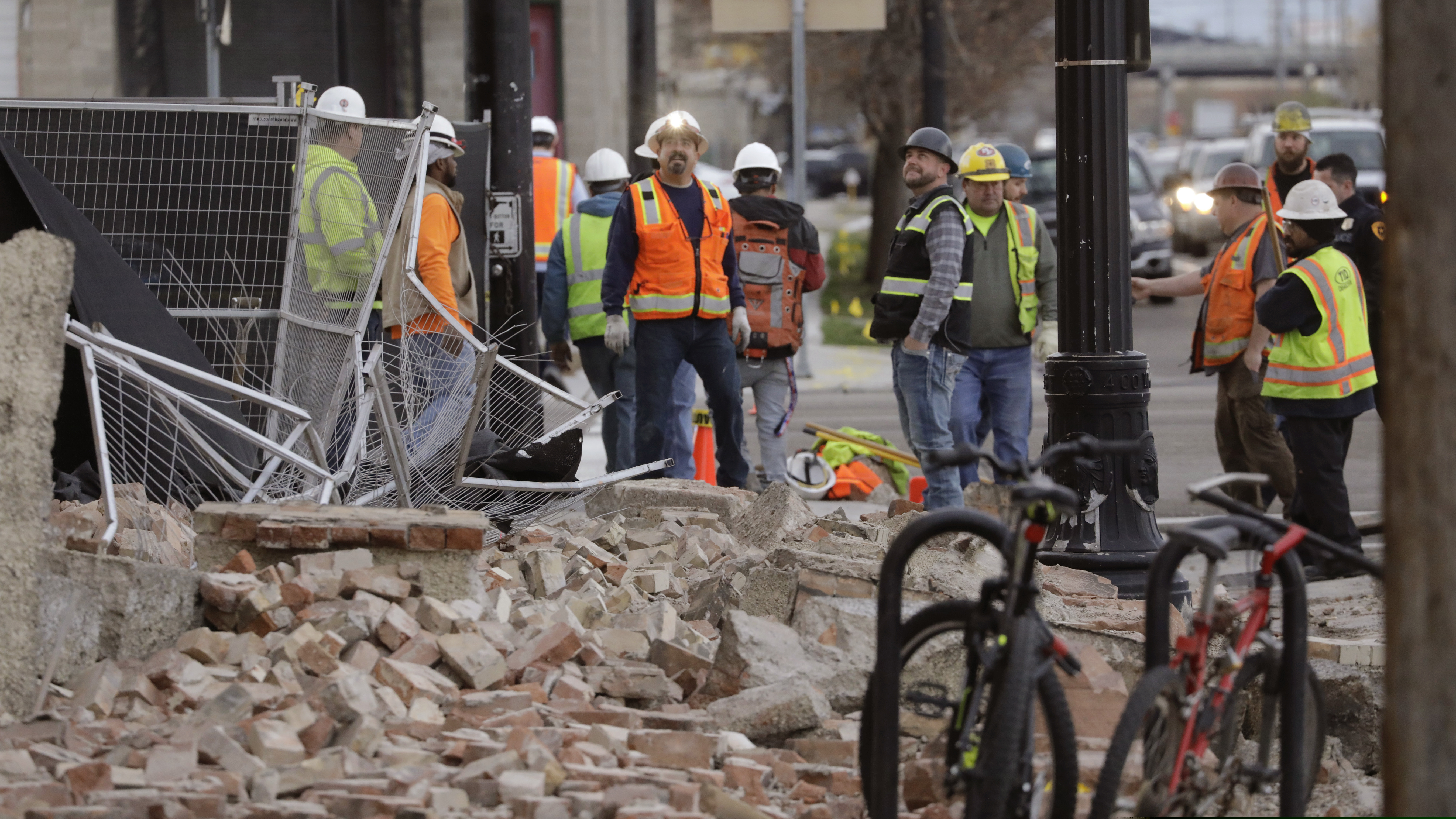 Construction workers looks at the rubble from a building after an earthquake Wednesday, March 18, 2020, in Salt Lake City. A 5.7-magnitude earthquake has shaken the city and many of its suburbs. The quake sent panicked residents running to the streets, knocked out power to tens of thousands of homes and closed the city's airport and its light rail system. (AP Photo/Rick Bowmer)