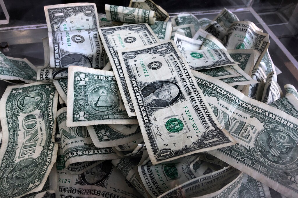 (AP Photo/Mark Lennihan, File) 2019 file photo a tip box is filled with U.S. currency in New York. Utah women need to improve their financial literacy, according to a new report from the Utah Women and Leadership Project.