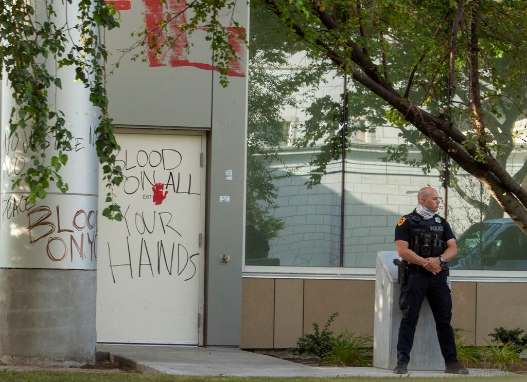 (Rick Egan  |  The Salt Lake Tribune) A Salt Lake City police officer stands guard in front of the Salt Lake County District Attorney's office, Friday, July 10, 2020.