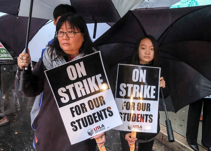 (Ringo H.W. Chiu | The Associated Press)  Faith Park, 13, holds a sign in support her mother Sarah Lee-Park during a teacher strike outside John Marshall High School, Monday, Jan. 14, 2019, in Los Angeles.Tens of thousands of Los Angeles teachers are striking after contentious contract negotiations failed in the nation's second-largest school district.