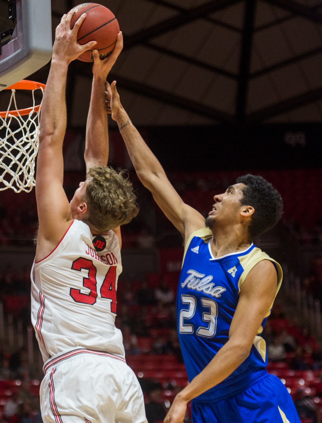 (Rick Egan  |  The Salt Lake Tribune)    Utah Utes center Jayce Johnson (34) dunks the ball, as Tulsa Golden Hurricane guard Zeke Moore (23) defends, in basketball action between, Utah Utes and Tulsa Golden Hurricane, at the Jon M. Huntsman Center, Saturday, Dec. 1, 2018.