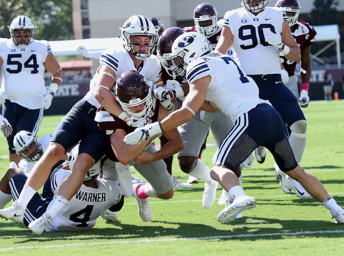 Mississippi State quarterback Nick Fitzgerald, center carries BYU defensive back Zayne Anderson, left, and defensive back Micah Hannemann (7) over the goal line for a touchdown during the first half of an NCAA college football game in Starkville, Miss., Saturday, Oct. 14, 2017. (AP Photo/Jim Lytle)