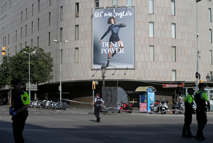 Police officers cordon off a street in Barcelona, Spain, Thursday, Aug. 17, 2017. Police in the northern Spanish city of Barcelona say a white van has jumped the sidewalk in the city's historic Las Ramblas district, injuring several people. (AP Photo/Manu Fernandez)