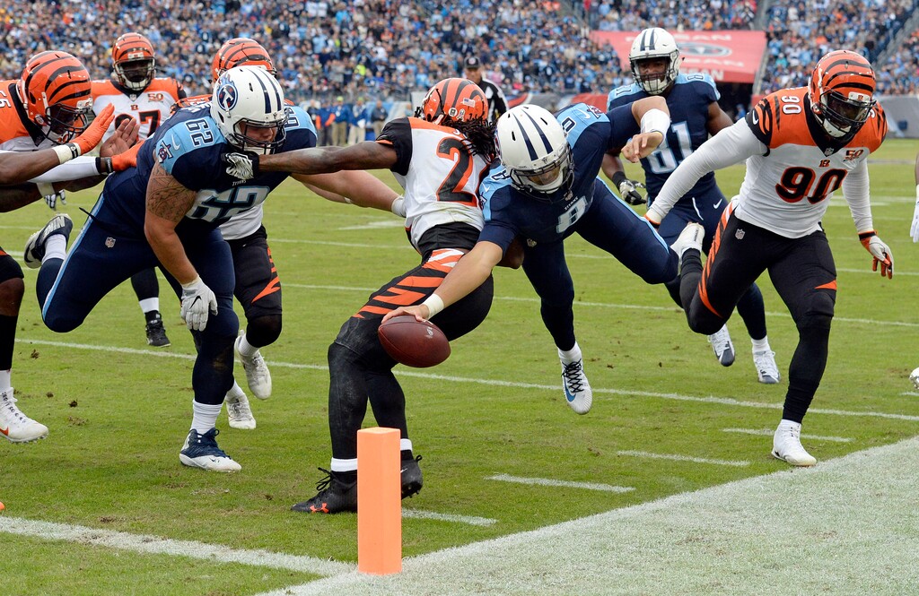 Tennessee Titans quarterback Marcus Mariota (8) falls just short of the goal line as he dives between Cincinnati Bengals defenders Adam Jones (24) and Michael Johnson (90) in the first half of an NFL football game Sunday, Nov. 12, 2017, in Nashville, Tenn. (AP Photo/Mark Zaleski)