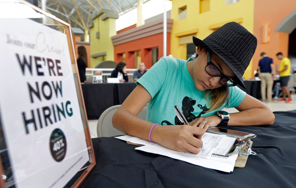 Job seeker Alejandra Bastidas fills out an application at a job fair, Tuesday, Oct. 3, 2017, at Dolphin Mall in Sweetwater, Fla. On Wednesday, Oct. 4, 2017, payroll processor ADP reports how many jobs private employers added in September. (AP Photo/Alan Diaz)