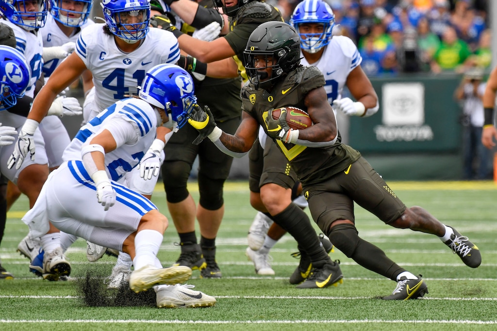 Oregon running back Mar'Keise Irving makes a cut as he rushes against BYU defensive back Ammon Hannemann and linebacker Keenan Pili during the first half of an NCAA college football game, Saturday, Sept. 17, 2022, in Eugene, Ore. (AP Photo/Andy Nelson)