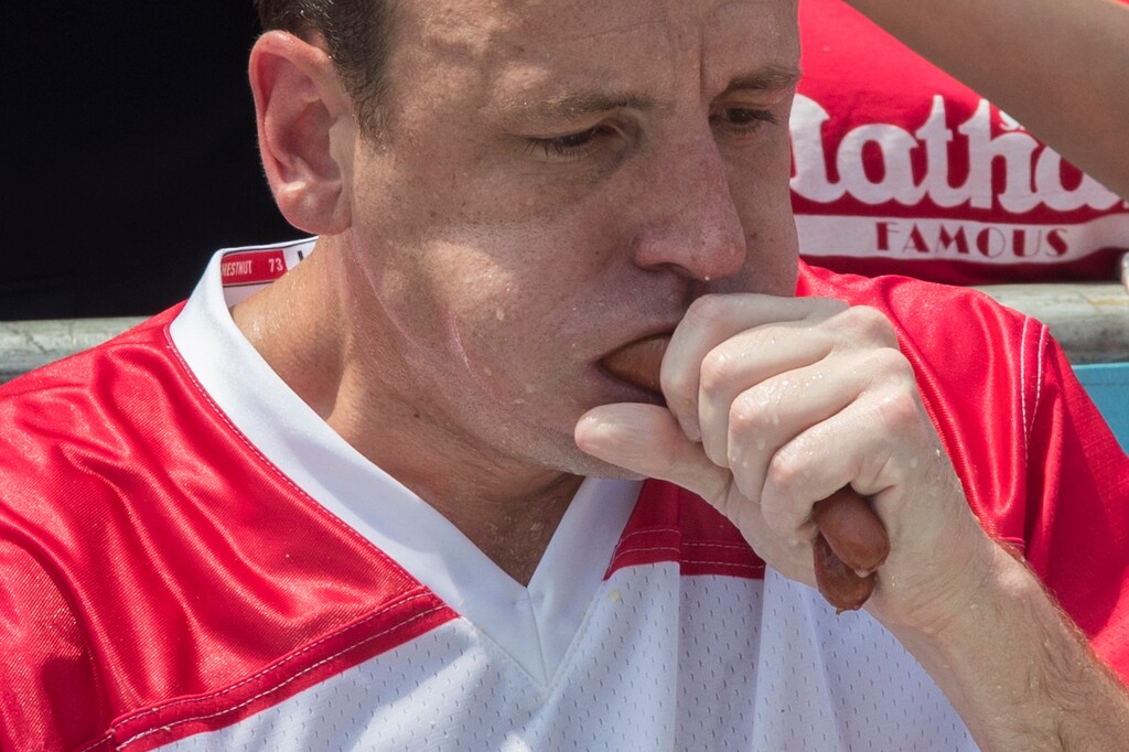 Reigning champion Joey Chestnut eats two hot dogs at a time during the men's competition of the Nathan's Famous Fourth of July hot dog eating contest, Wednesday, July 4, 2018, in New York's Coney Island. The defending champion  broke his own world record by eating 74 hot dogs in 10 minutes. (AP Photo/Mary Altaffer)